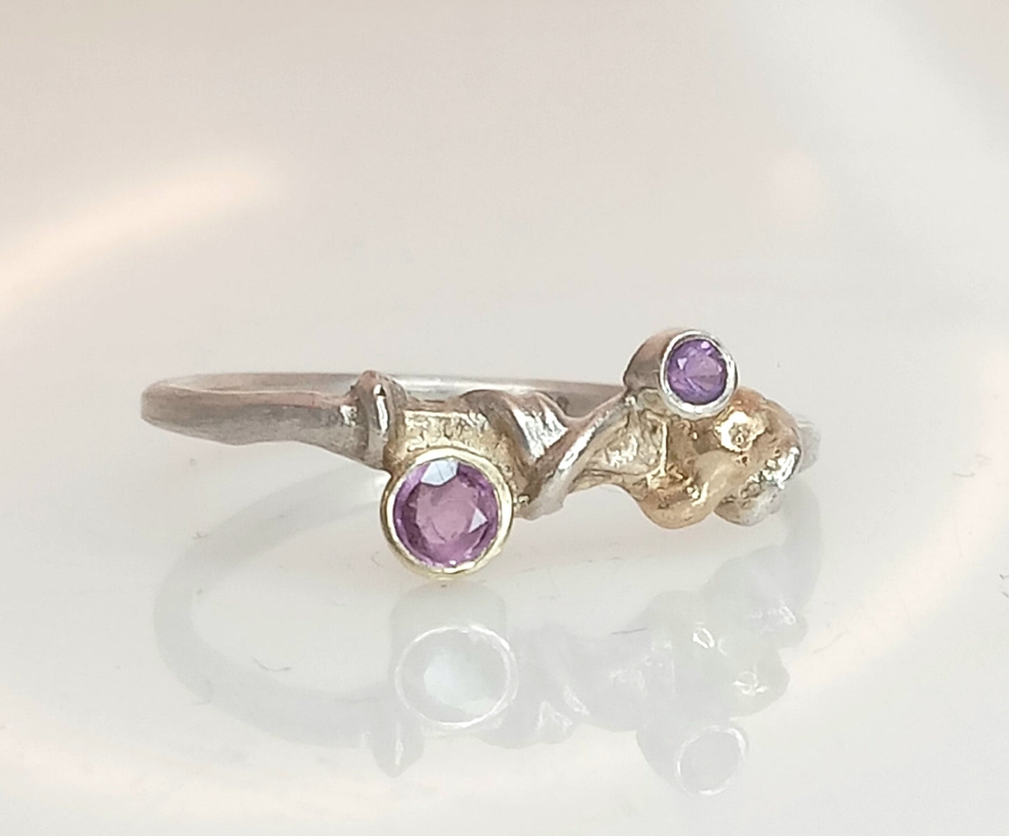 
                  
                    Handmade ring featuring a 3 mm pink sapphire and 2 mm amethyst on a 1.5 mm recycled silver band, sapphire set in 585 gold, ring size 56.5, unique piece from the Überwachsen collection
                  
                