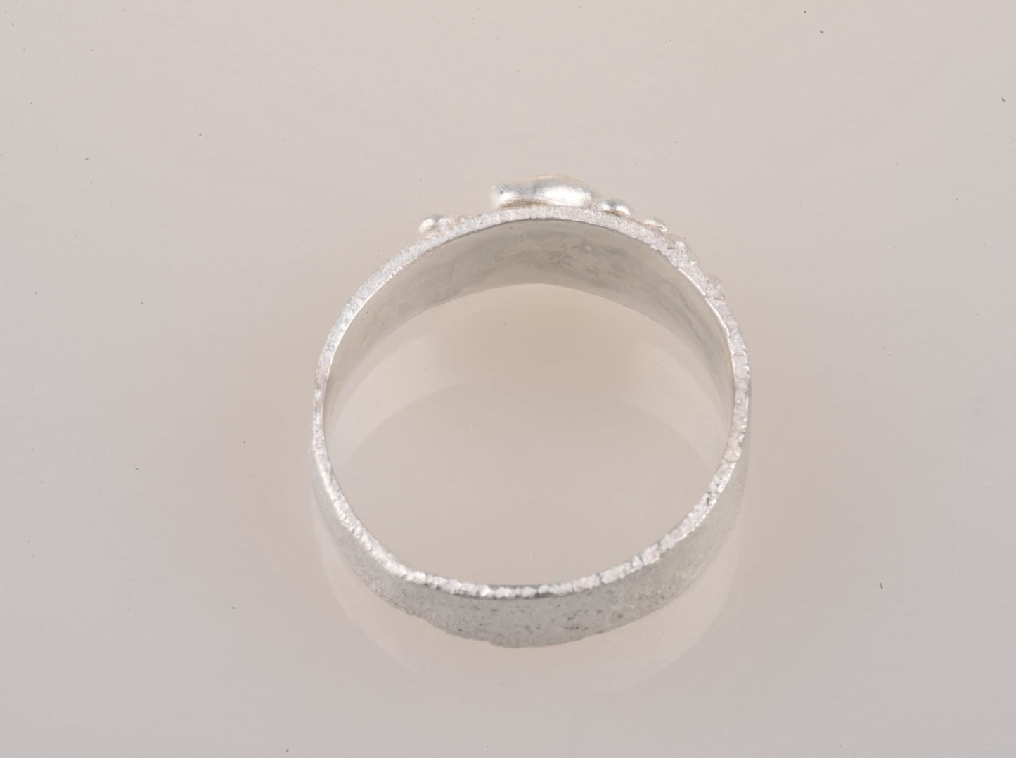 
                  
                    Für Neptuns Töchter könnte dieser Granulatring für Ariel sein. Einzigartig in recyceltem Silber, ist das Band sorgfältig mit einzeln gelöteten, handgefertigten Granulaten verziert, die eine leuchtende, ovale Süßwasserperle umgeben.  Der Ring ist super bequem, da er hinten von 6 mm auf 4 mm abfällt und nur 1 mm dick ist. 
                  
                