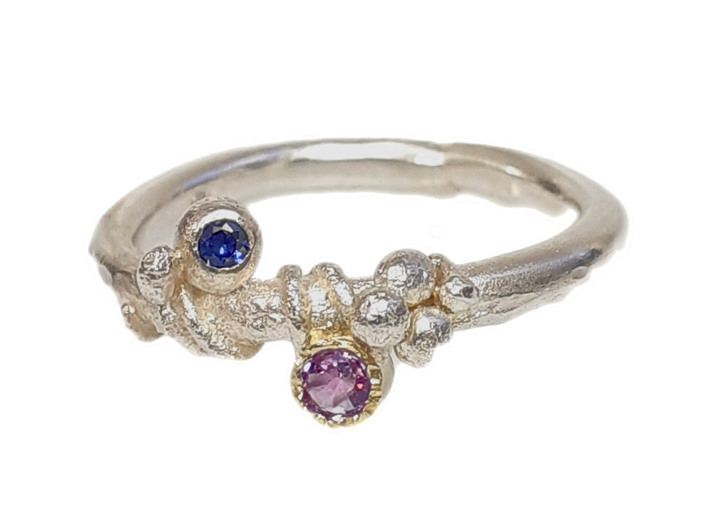 Saphire gibt es in allen Farben des Regenbogens. Bei diesem Ring kontrastiert ein tiefblauer Saphir mit einem rosa, fast lavendelfarbenen Saphir. Wie die Farben des Sonnenuntergangs.