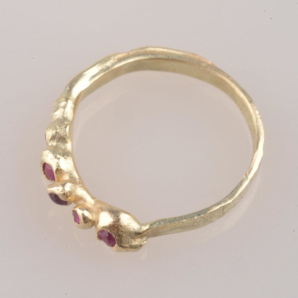 Dieser zarte Ring sieht aus, als könnte er aus der Erde wachsen. Die fünf Rubine sind alle leicht schräg zueinander gefasst, so dass sich aus jedem Blickwinkel eine andere Perspektive ergibt.