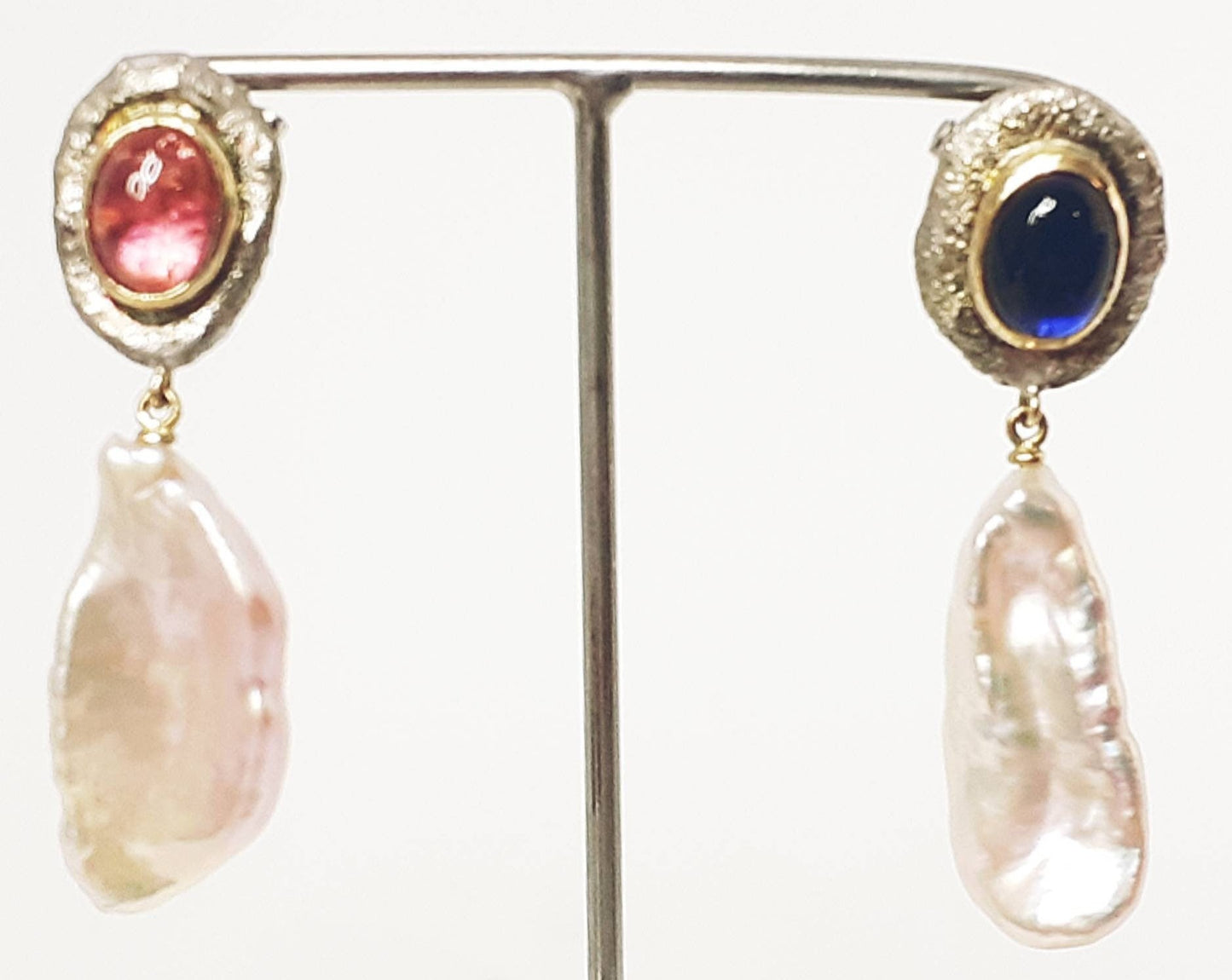 
                  
                    Sweetwater Perlen Ohrringe mit Kyanit und Turmalin. Diese Perlen schimmern in Rosa- und Apricot-Tönen. Die kontrastierenden blauen Kyanite und rosa/orangen Turmaline, gefasst in recyceltem 14-Karat-Gold, ergänzen die Perlen wunderbar. Einzigartige Ohrringe für eine außergewöhnliche Person.
                  
                