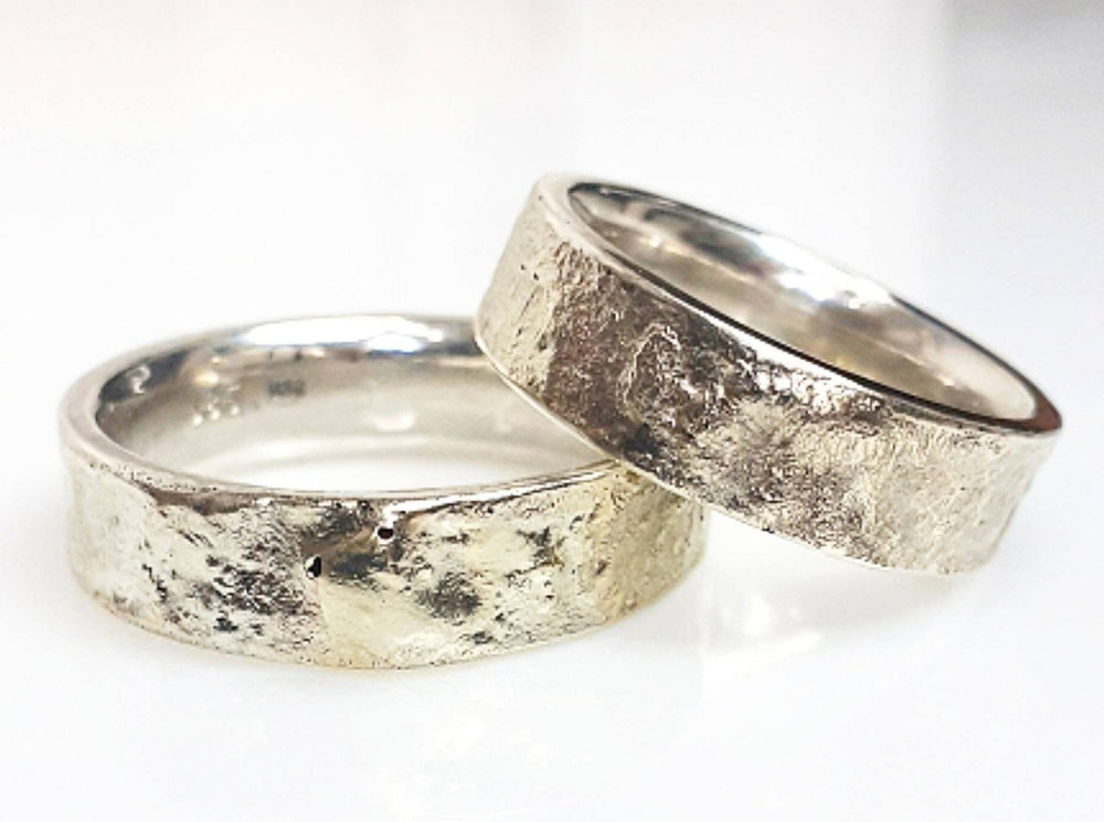 Diese ungewöhnlichen Eheringe haben eine schöne, rustikale Struktur. Jeder Ring ist einzigartig und handgefertigt. Das Band ist aus 5,5 mm breitem, 1,8 mm dickem Silber. 2 Gramm 14-karätiges Gold sind sorgfältig mit der Oberfläche verschmolzen. Durch dieses Verfahren entsteht einzigartiger Trauringe, so dass keine zwei Ringe jemals gleich sein können
