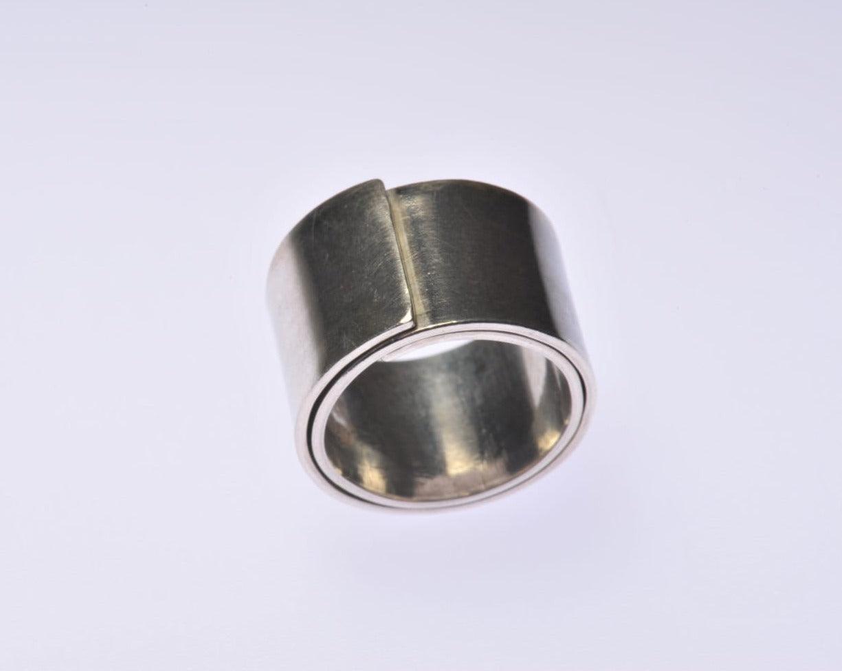 
                  
                    Dieser breite Silberring ist gewickelt, das heißt, die Spannung des Metalls sorgt dafür, dass er seine Form behält. Dieser Ring kann sowohl von einem Mann als auch von einer Frau getragen werden und ist aufgrund seiner Breite perfekt für den Mittelfinger geeignet. Der Ring ist 14 mm breit und aus 1 mm dickem Sterlingsilber gefertigt. In seiner jetzigen Größe ist der Ring 2 mm dick, aber das könnte sich ändern, wenn die Größe geändert wird.
                  
                
