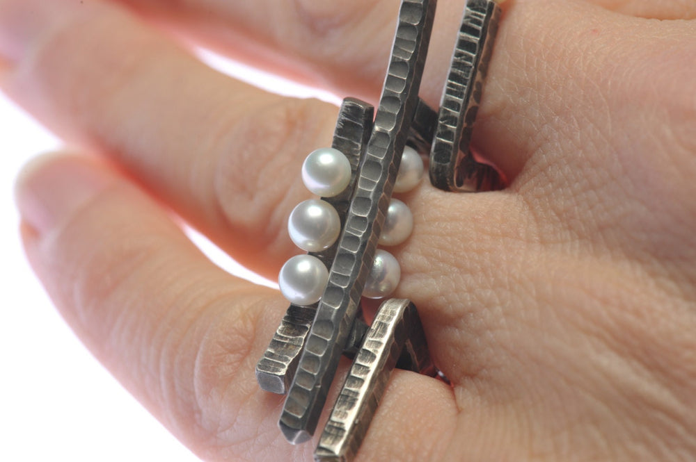 
                  
                    Dieser Omega Ring ist wirklich etwas Besonderes. Ein moderner Perlenring in gehämmertes, oxidiertes Silber im Kontrast zu leuchtend, weißen, echter Akoya Perlen.  Der Silberdraht hat ein 3 mm breites, quadratisches Profil.  Der Ring ist ein US 6, UK L1/2, European 12 (52mm Fingerumfang)
                  
                