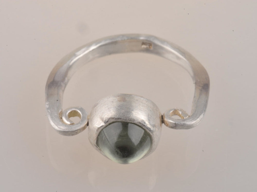 
                  
                    Dieser Ring ist Teil einer Serie, die durch eine Ausstellung römischer Funde in der Gegend, in der ich lebe - dem Rheintal - inspiriert wurde. Der Stein ist ein Prasiolith, auch als grüner Amethyst bekannt. 
                  
                